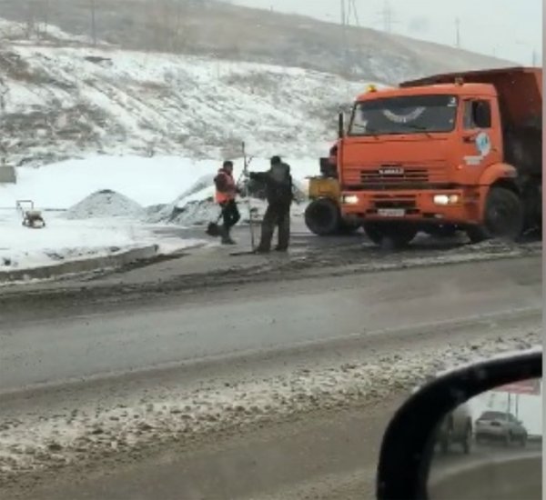 В Красноярске рабочие уложили асфальт на дорогу в снег и грязь